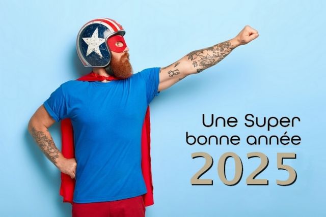 Profile shot of serious bearded man makes flying gesture, looks into distance, wears protective helmet and red cape, poses against blue background with empty space for your promotional content